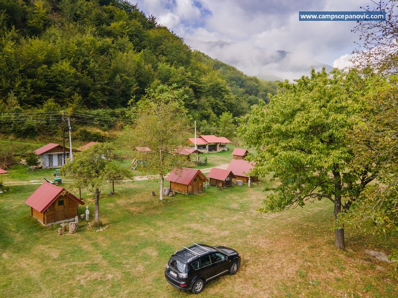 Camp area with cabins and parked car