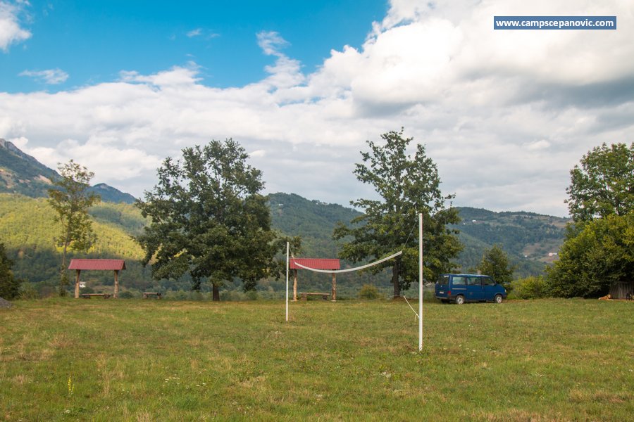 Camping field with volleyball net and blue van