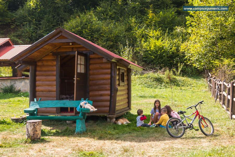 Wooden cabin with bench and children outside