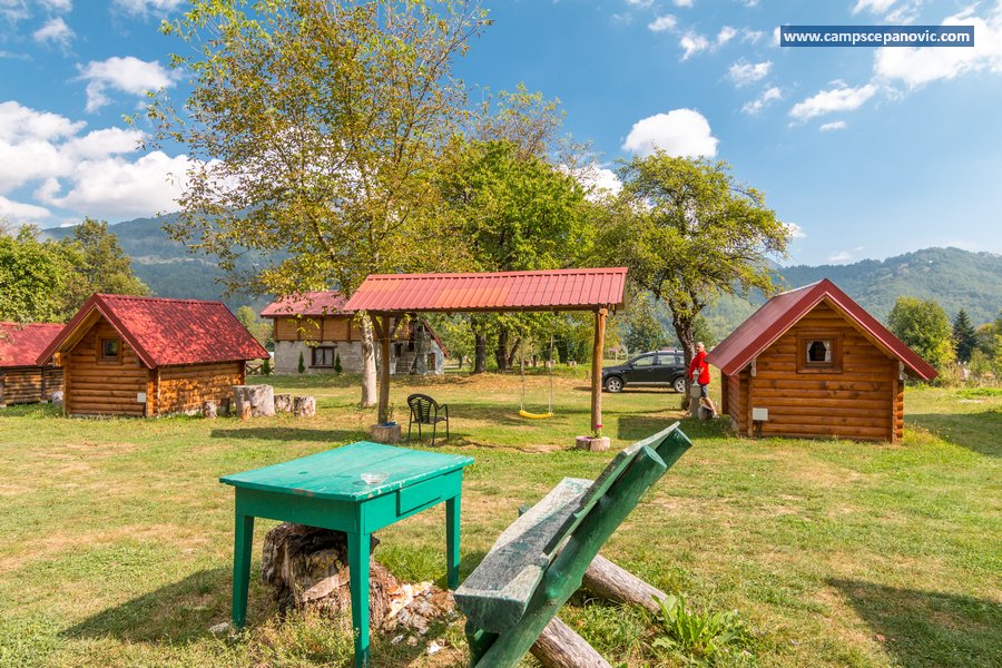 Cabins, swing and outdoor benches in the camp