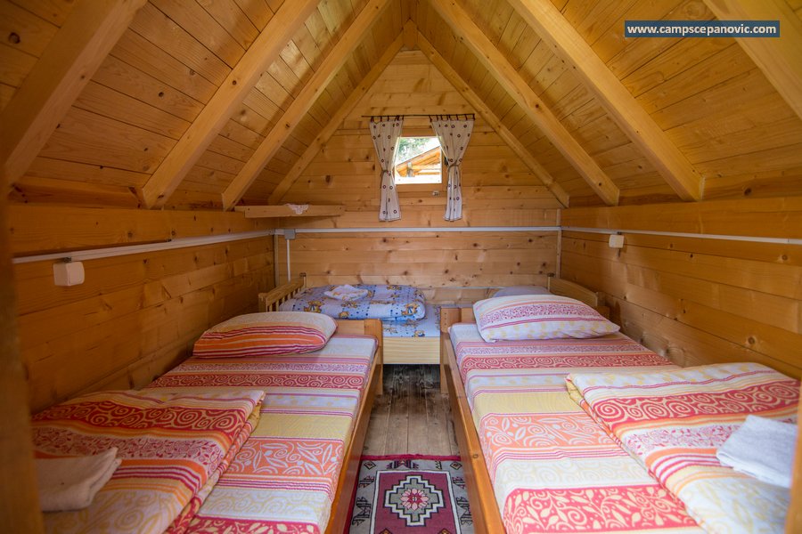 Small wooden cabin interior with several beds