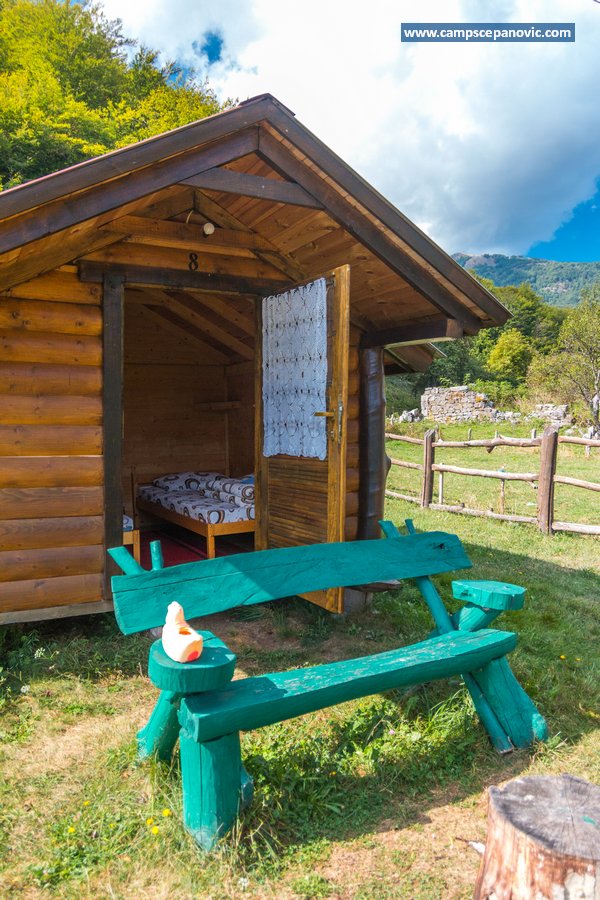 Open cabin door with green bench outside