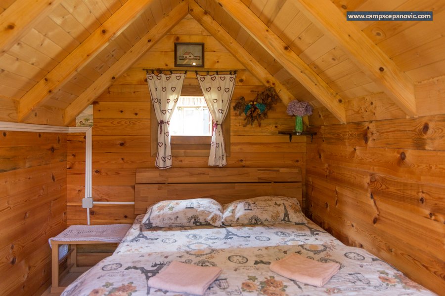 Double bed in wooden cabin