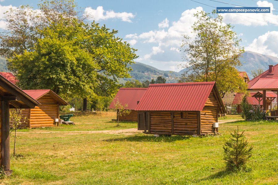 Cabins with red roofs and mountain backdrop