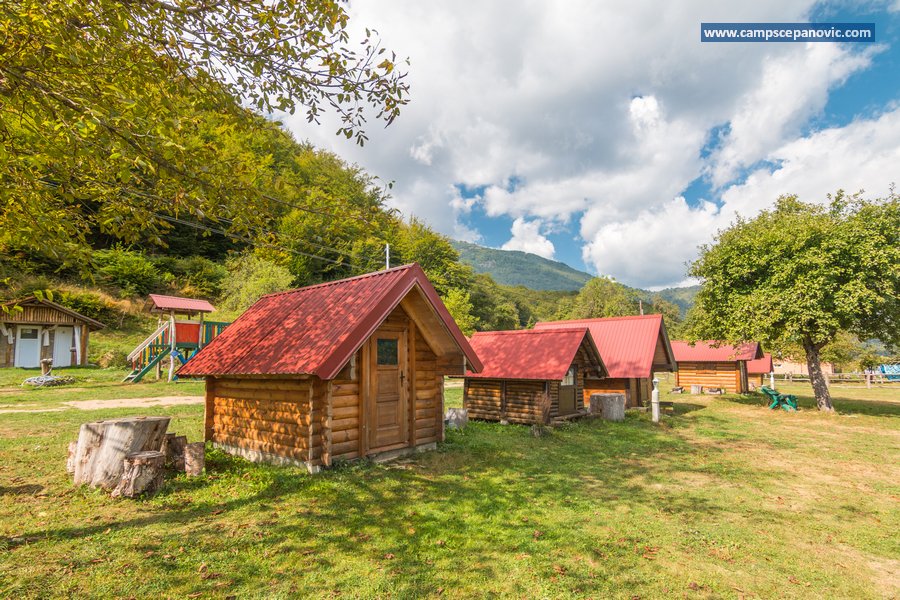 Wooden cabins in the camp with red roofs and mountain view